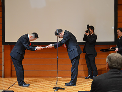 高橋理事長から表彰を受ける入賞社の代表